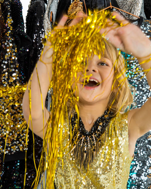 Christmas Winter small Girl blowing Magic gold snow in Her Hand. Fairy. Beautiful New Year and Xmas scene. Holiday mood, Gift. Beauty kid playing on Holiday winter sequins Background, sales concept