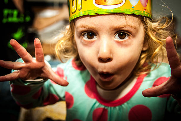 a little child doing scary faces in her birthday party